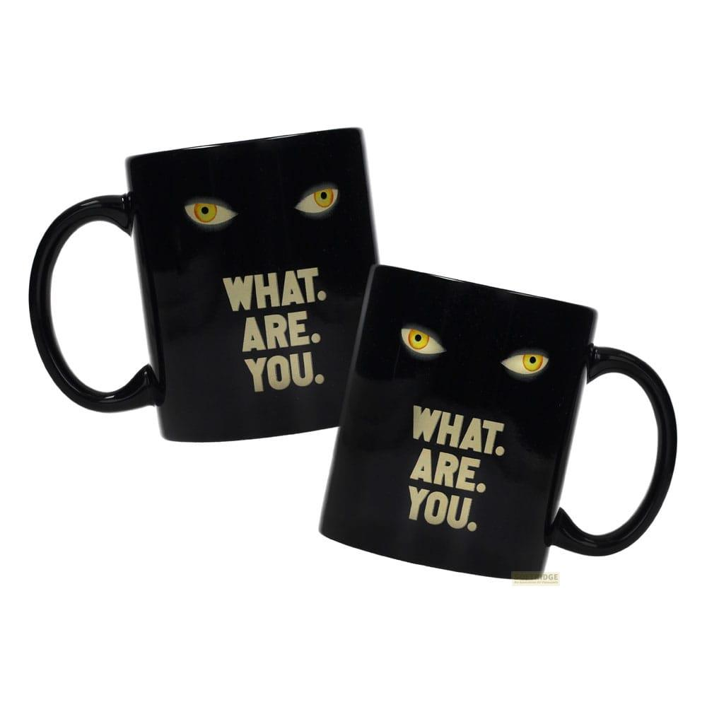 Dos tazas negras con ojos amarillos y texto.
