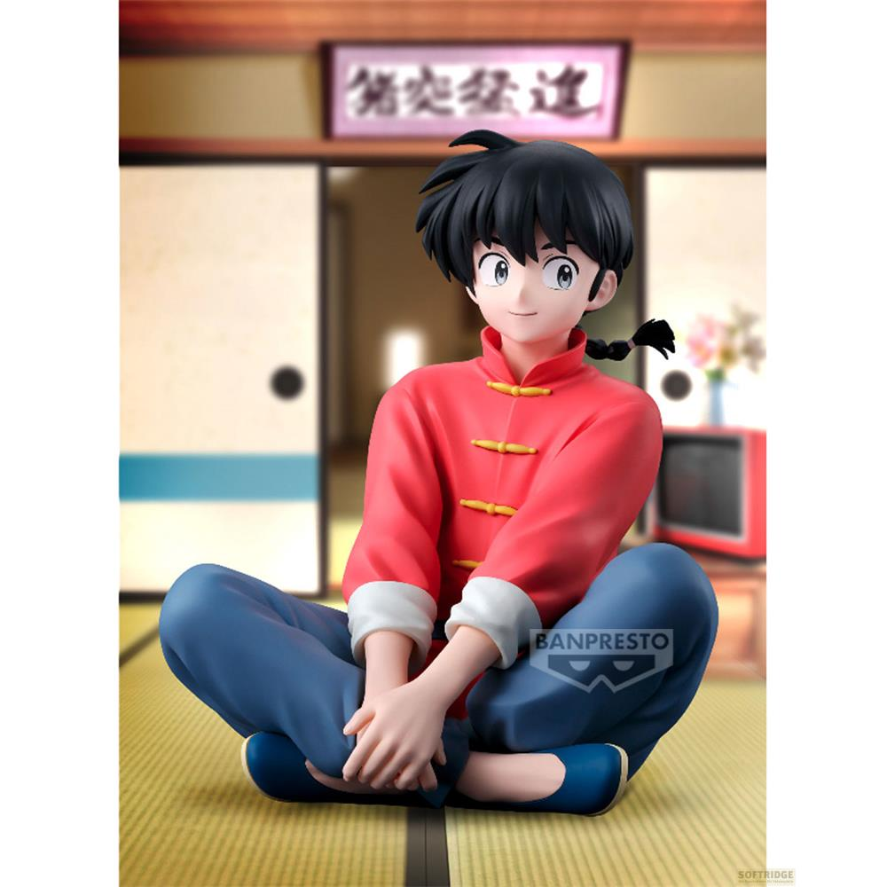 Una figura de anime vestida de rojo y azul se sienta con las piernas cruzadas.