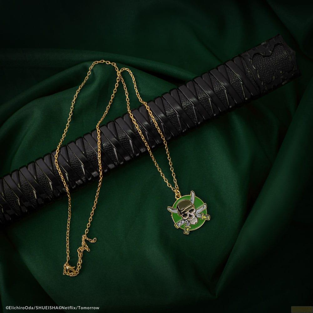 Collar dorado con colgante de calavera sobre empuñadura de espada negra.