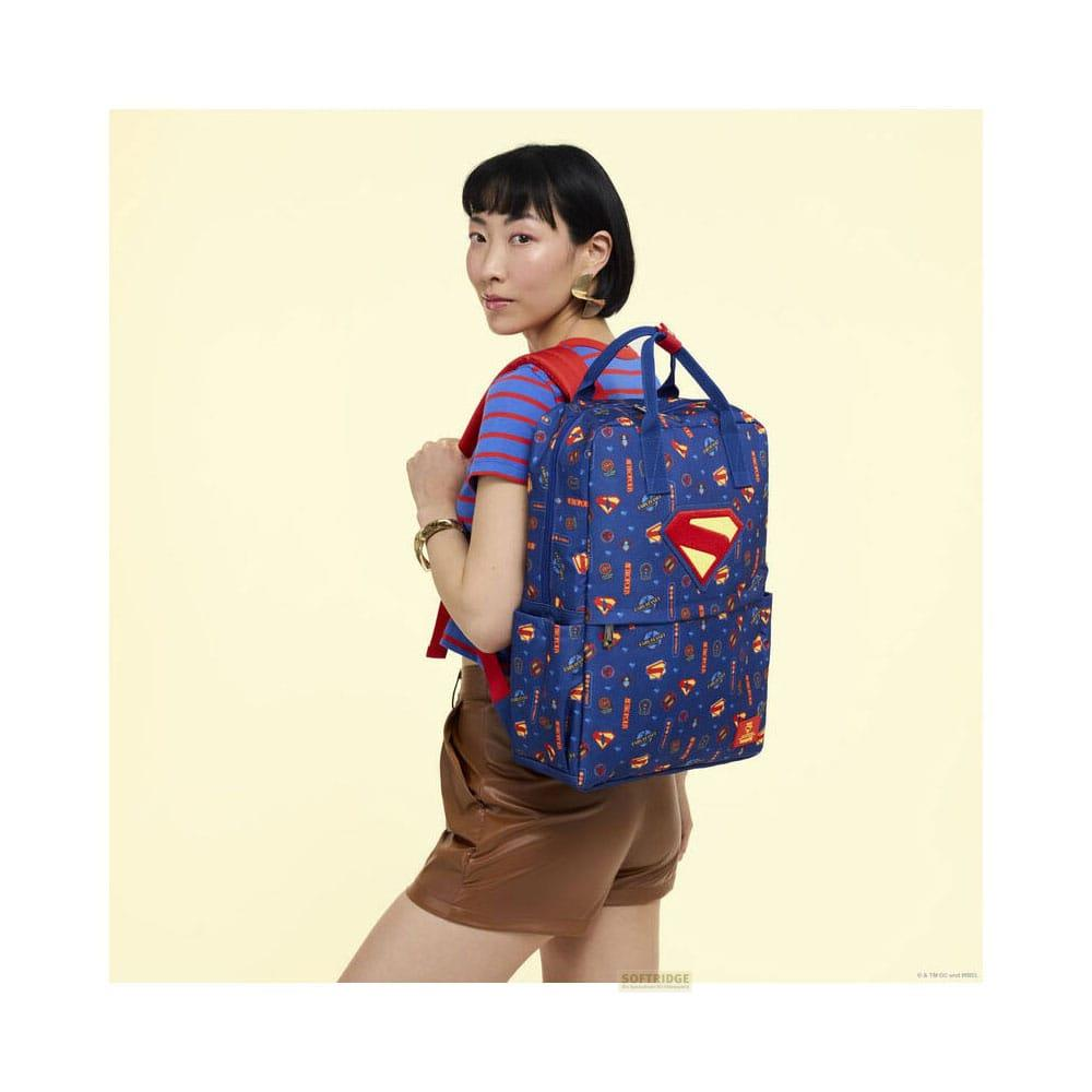 Una mujer con mochila azul de Superman sobre fondo amarillo.