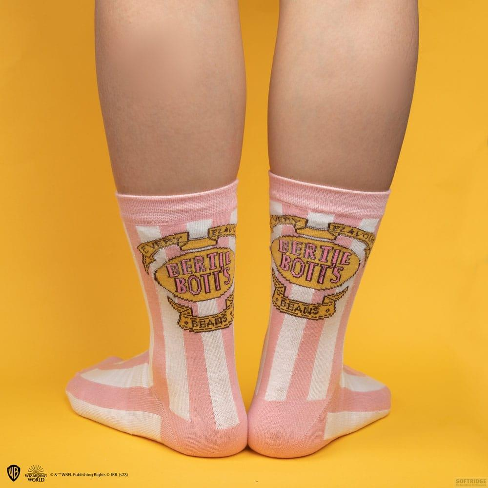 Calcetines rosas y blancos con estampado Bertie Bott's Beans sobre fondo amarillo.