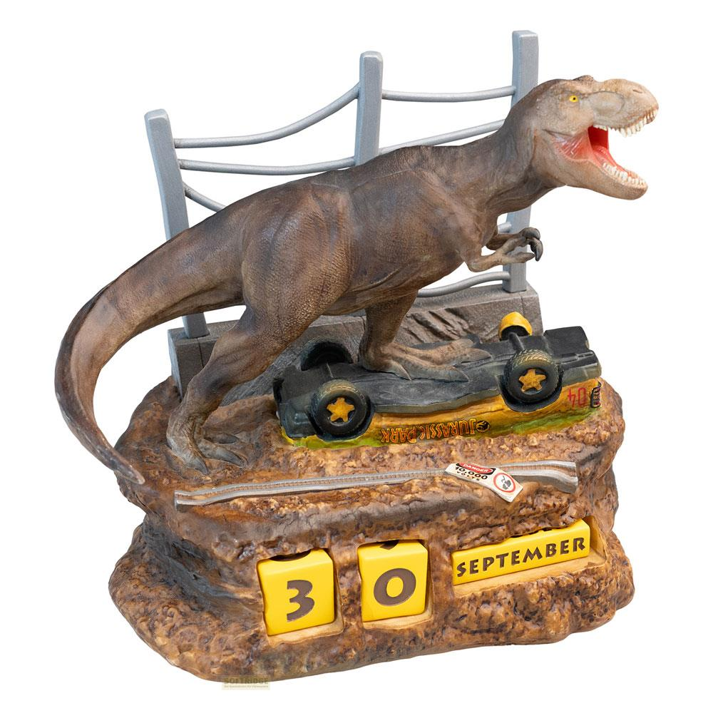 Un modelo de T-Rex está sobre un Jeep volcado frente a una valla. Un calendario muestra el 30 de septiembre.