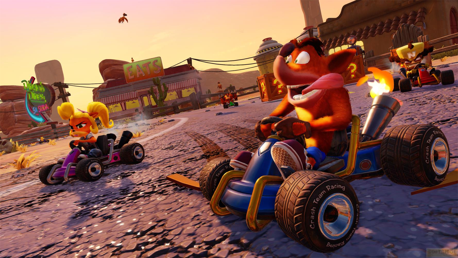 Crash Bandicoot und Coco rasen in Karts durch eine Wüstenlandschaft.