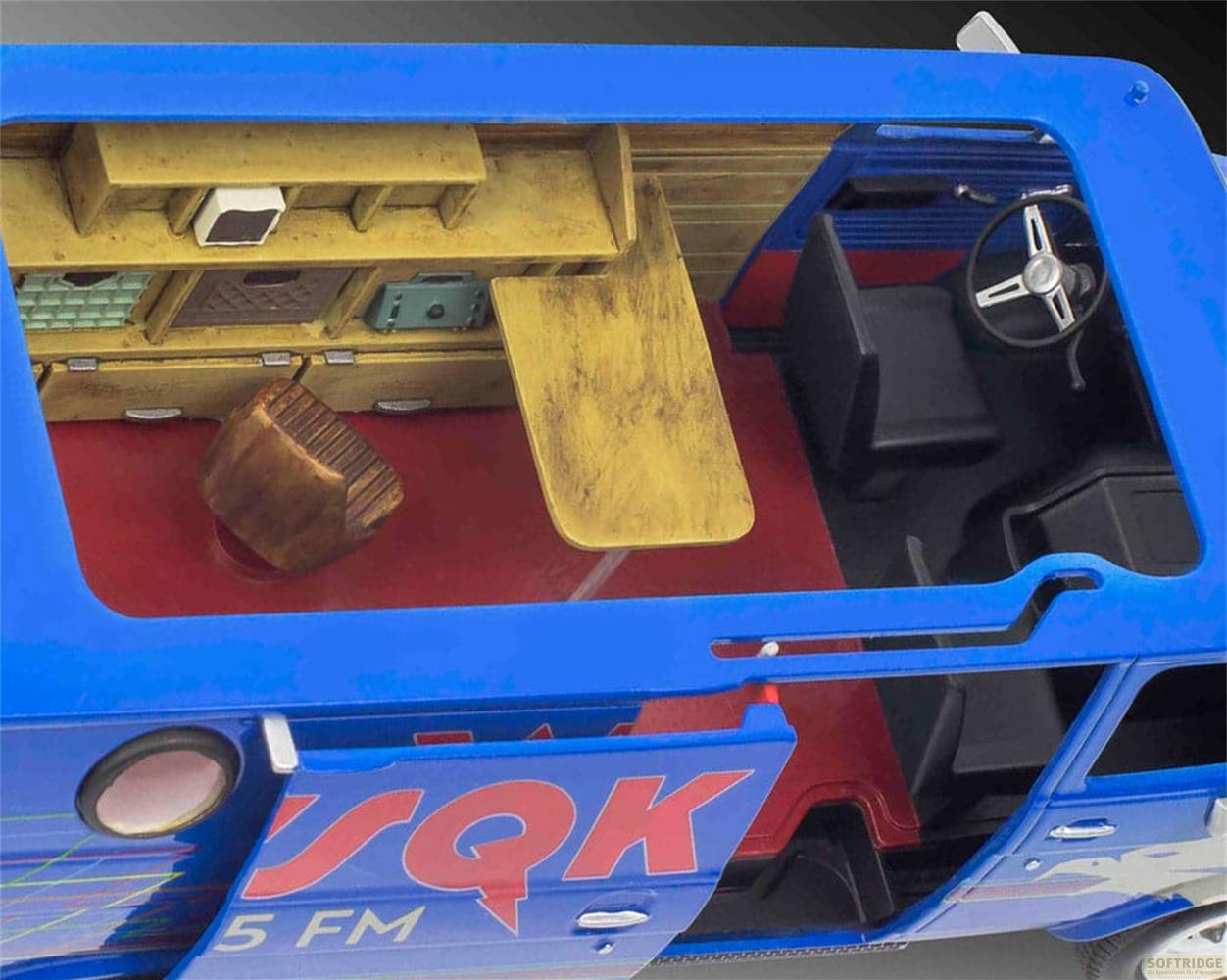 Vue intérieure d'une camionnette jouet bleue avec sièges rouges, étagères et volant.