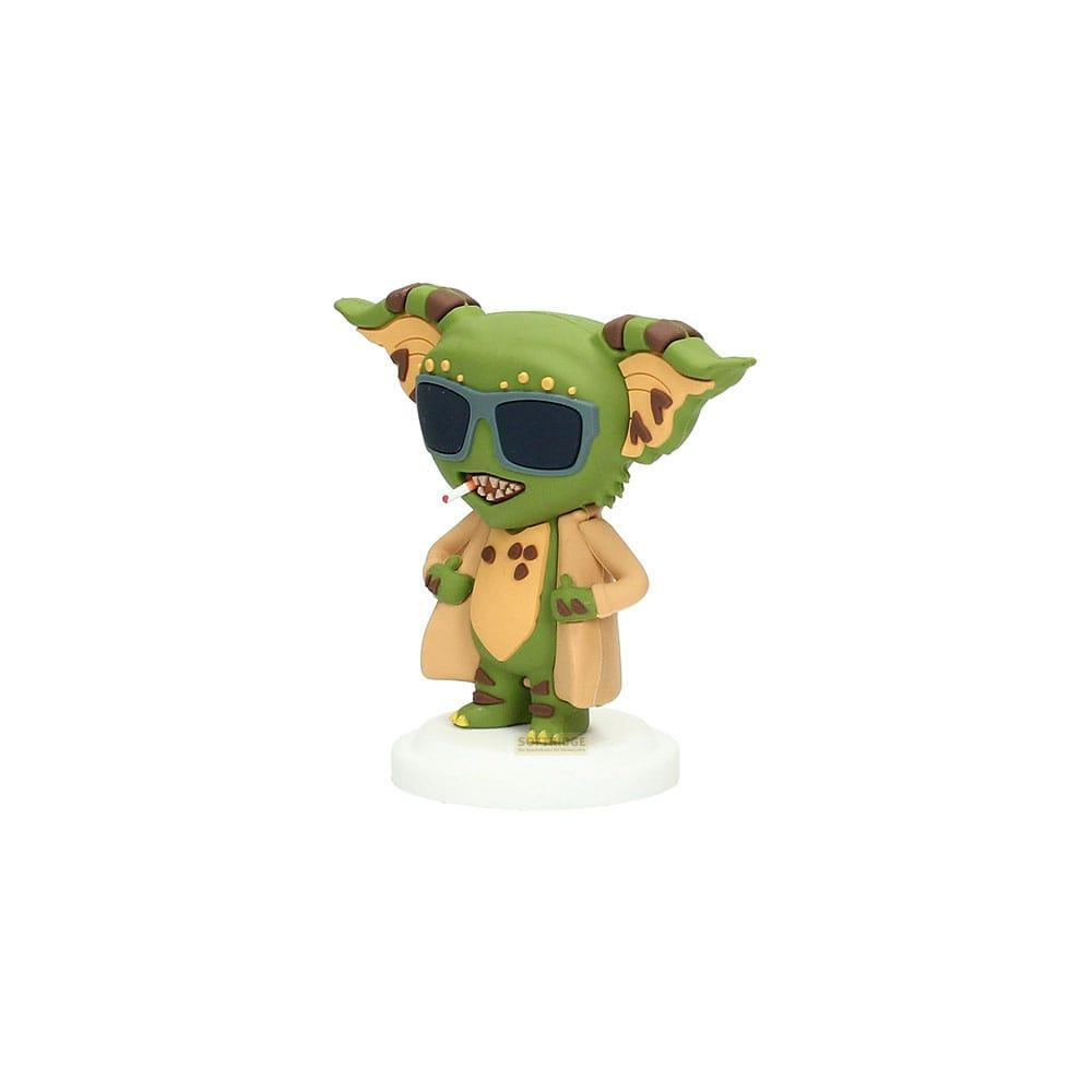 Figura verde con gafas de sol y cigarrillo, vestida con abrigo.