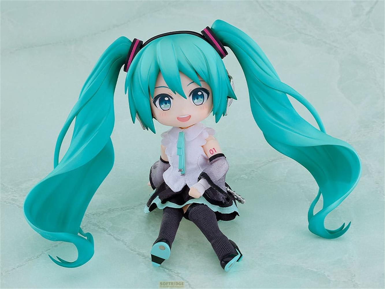Una simpatica figura anime con capelli turchesi e cuffie seduta su sfondo verde chiaro.