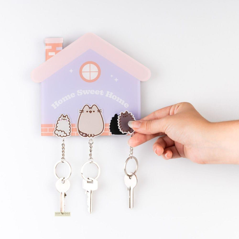 Un llavero con forma de casa con gatos Pusheen y tres llaves.