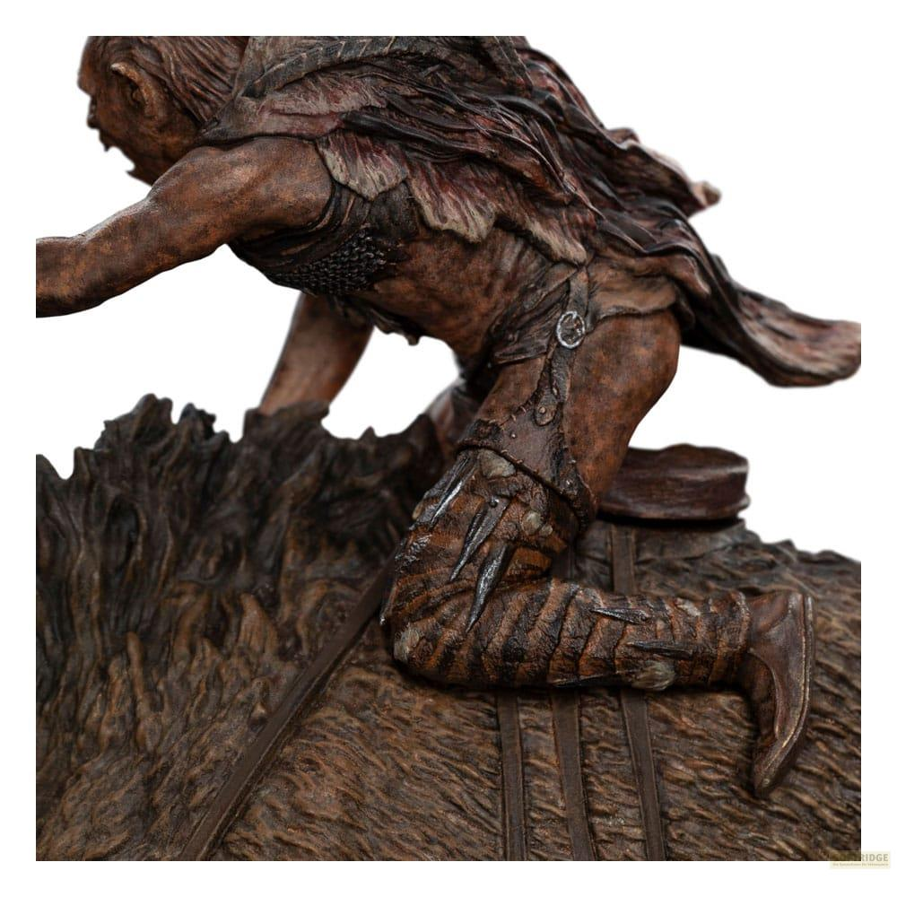 Una figura con armadura de cuero escala un terreno rocoso.