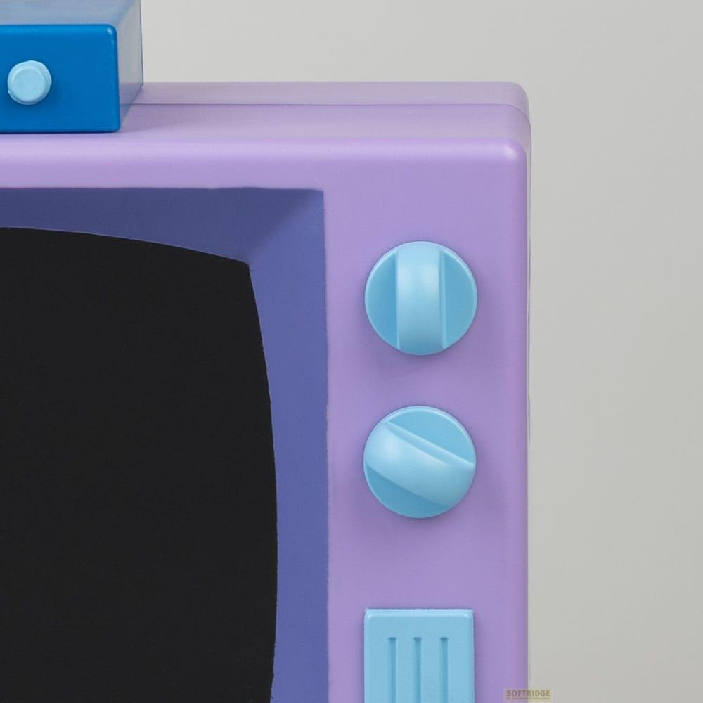Televisor morado con dos perillas azules y una caja azul encima.