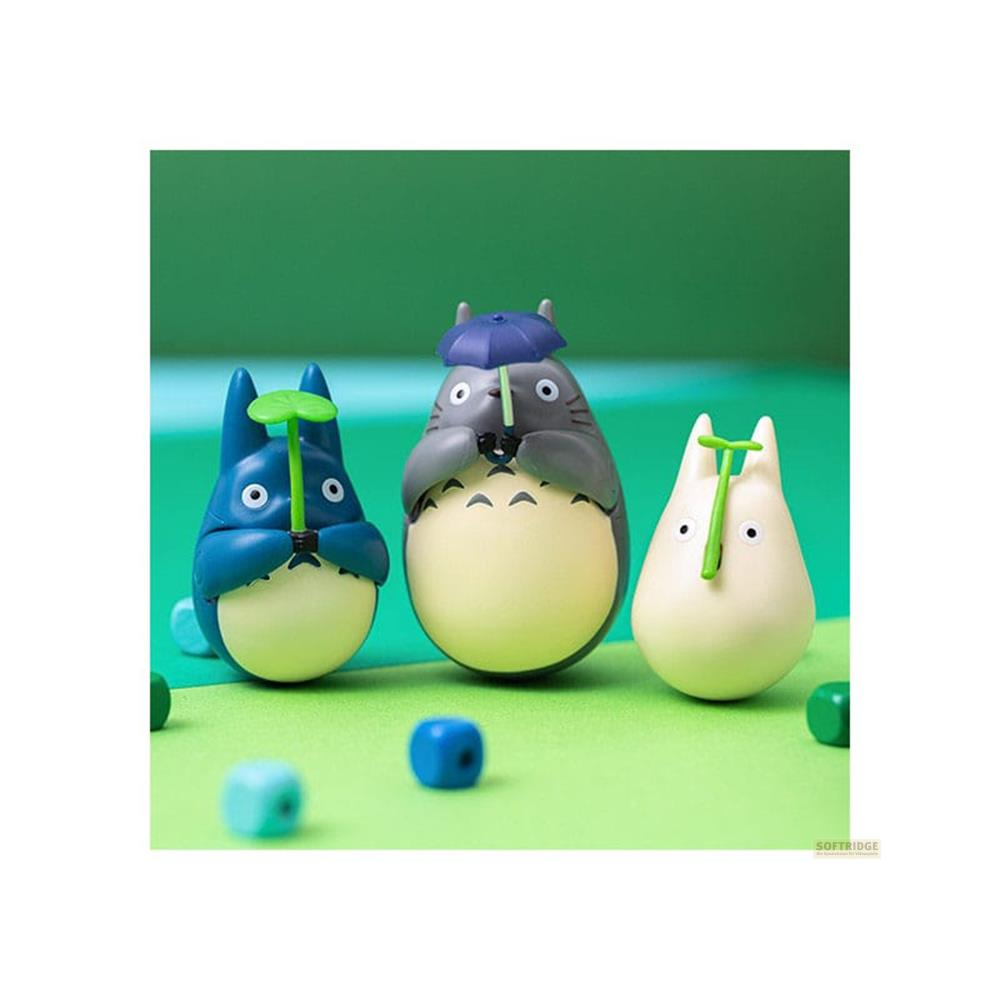 Trois figurines Totoro sur fond vert. Deux tiennent des feuilles, un parapluie.
