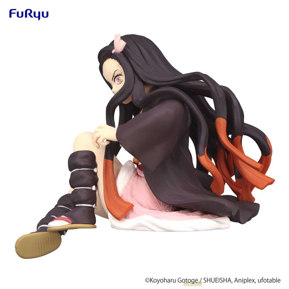Eine Figur von Nezuko Kamado sitzt, trägt ein dunkles Kleid und rosa Unterkleid.