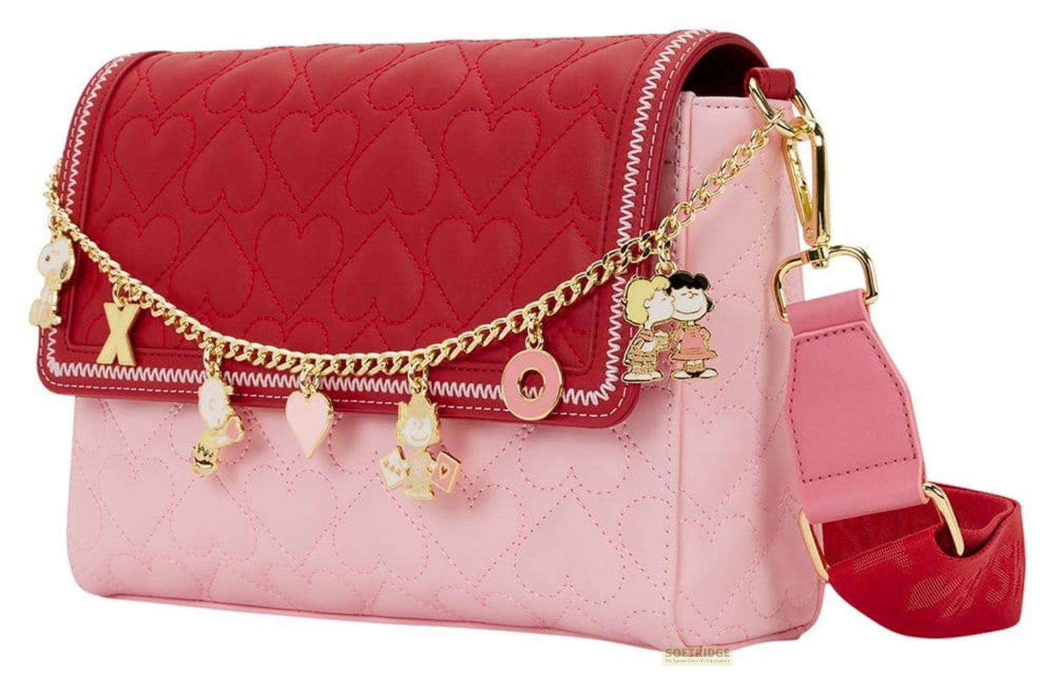 Un bolso rosa con solapa de corazón rojo, dijes y correa.