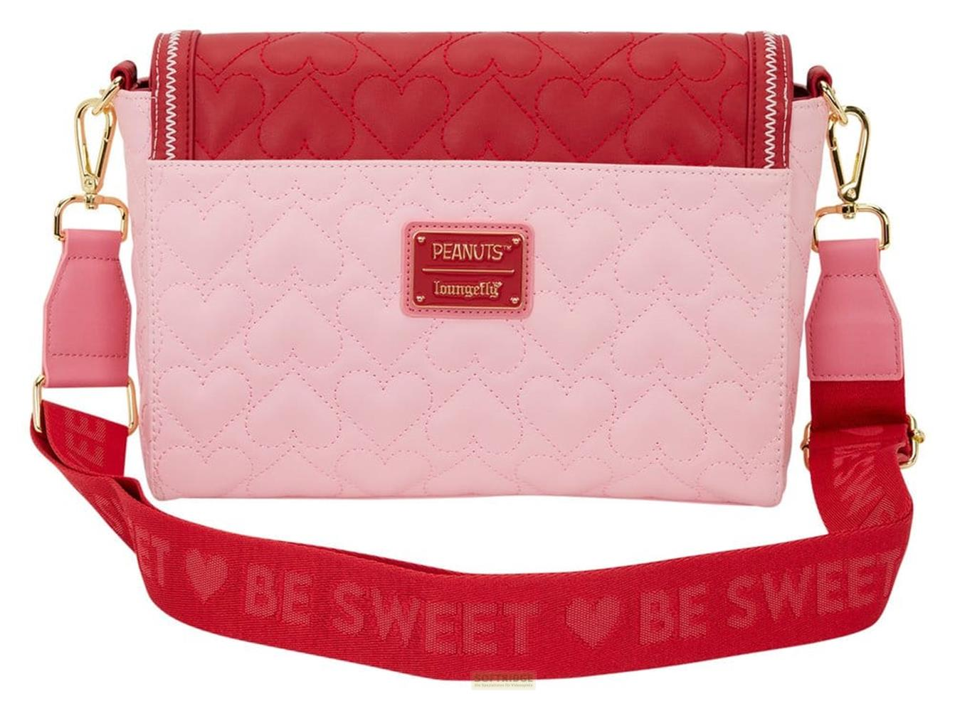 Un bolso rosa acolchado con corazones y correa roja que dice "BE SWEET".