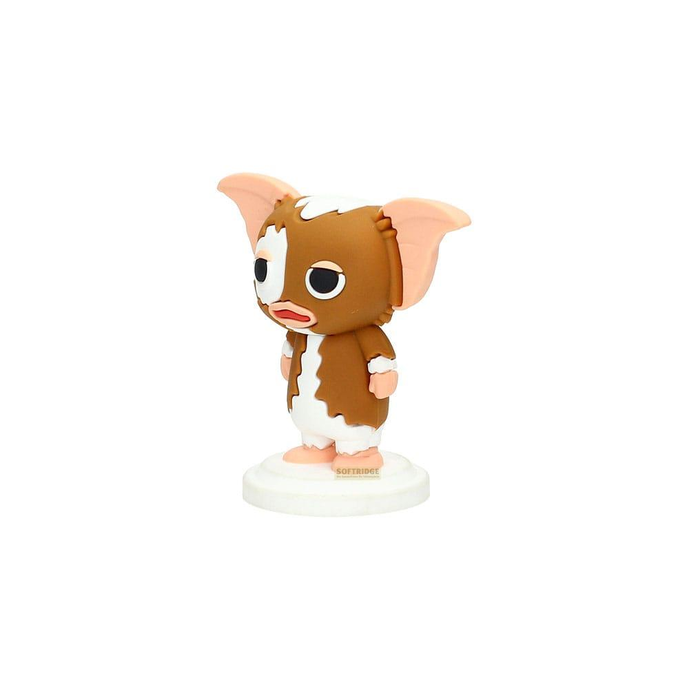 Una figura marrón y blanca de Gizmo se alza sobre una base blanca.