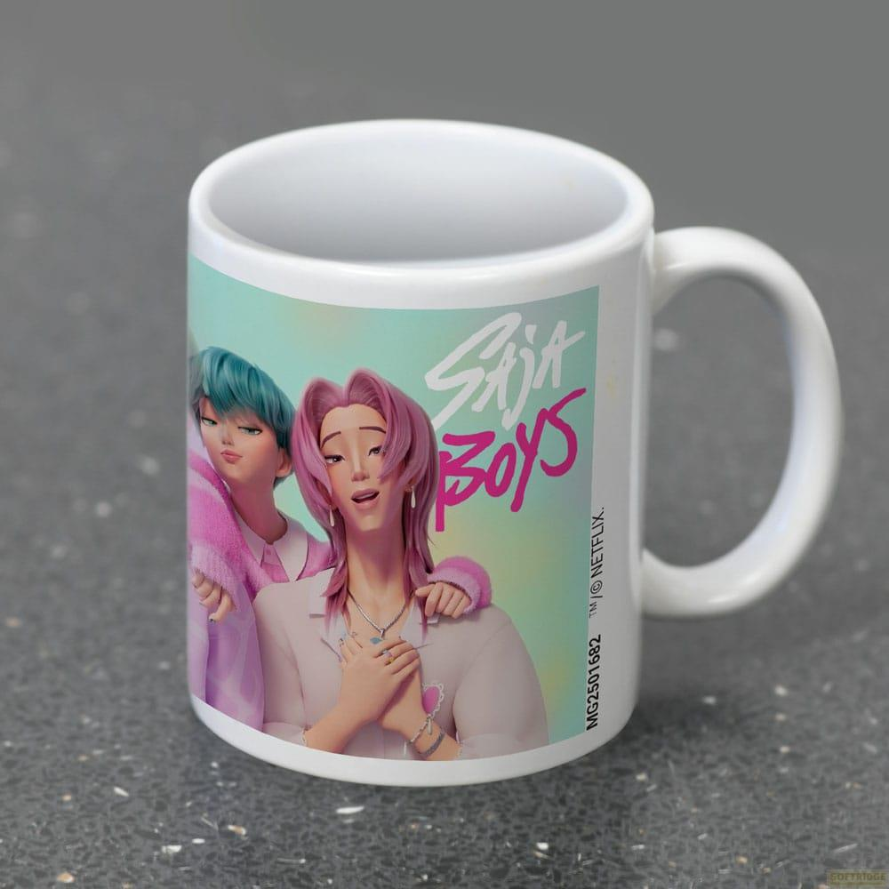 Una taza con "Saja Boys" y dos personajes animados, uno de pelo rosa, otro azul.