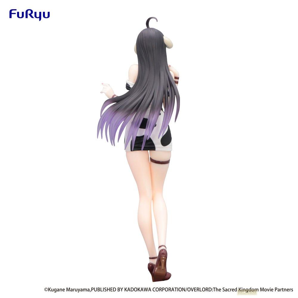 Figura de mujer con pelo oscuro, vestido estampado de vaca, acentos blancos y morados.