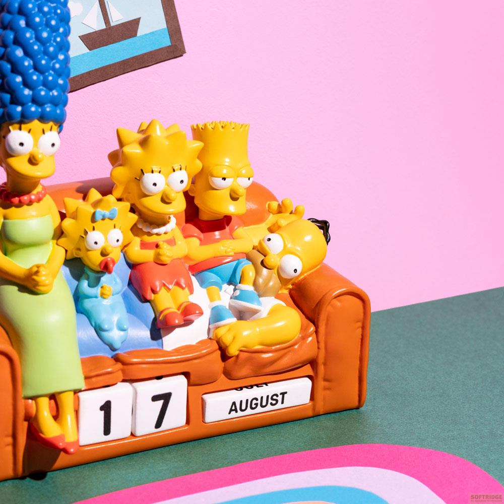 Las figuras de Los Simpson sentadas en un sofá frente a un fondo rosa. Calendario muestra 17 de agosto.