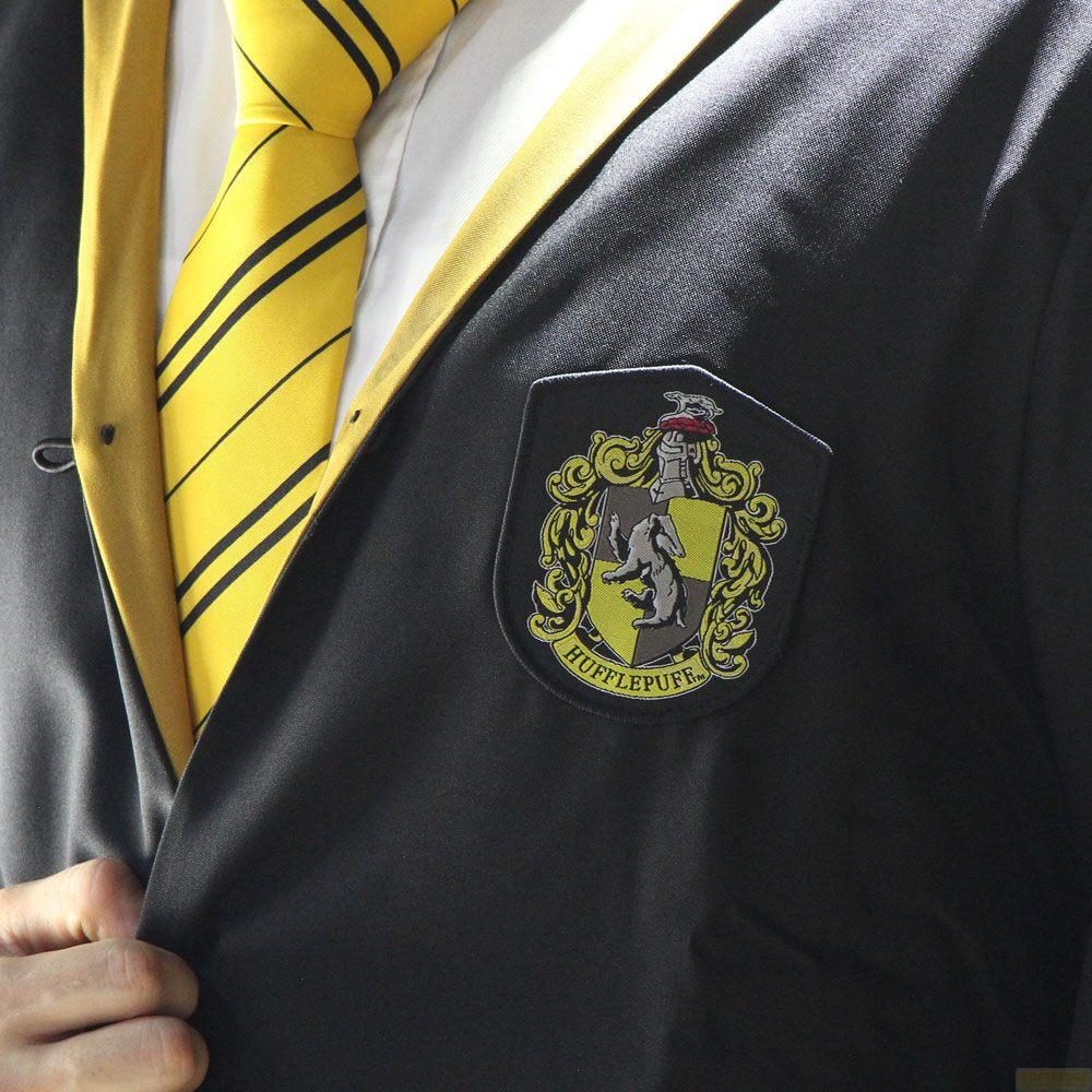 Túnica oscura con corbata a rayas amarillas y negras y escudo Hufflepuff.