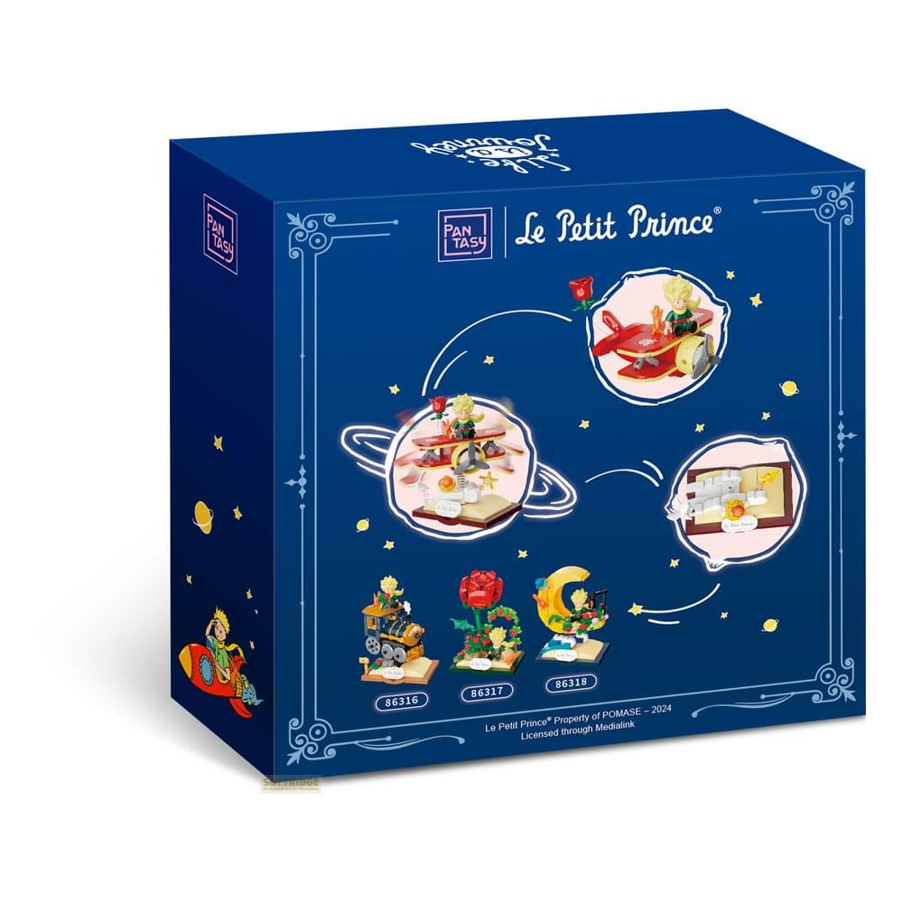Box-Art für 'Der kleine Prinz'-Spielzeug. Zeigt Planetenszenen, eine Rose und einen Zug.