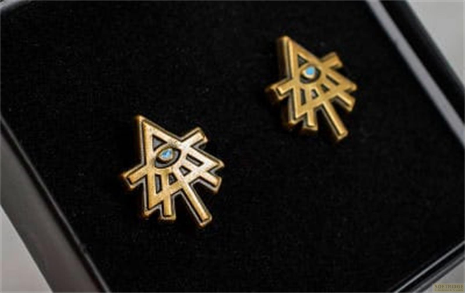 Zwei goldene Triforce-Symbole mit blauen Edelsteinen in einer schwarzen Box.