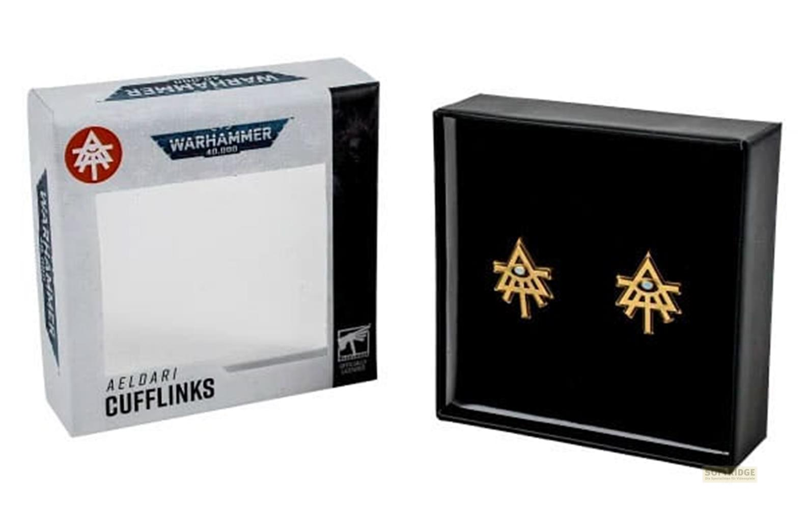 Goldene Aeldari Manschettenknöpfe mit blauem Stein in schwarzer Box neben Warhammer-Verpackung.