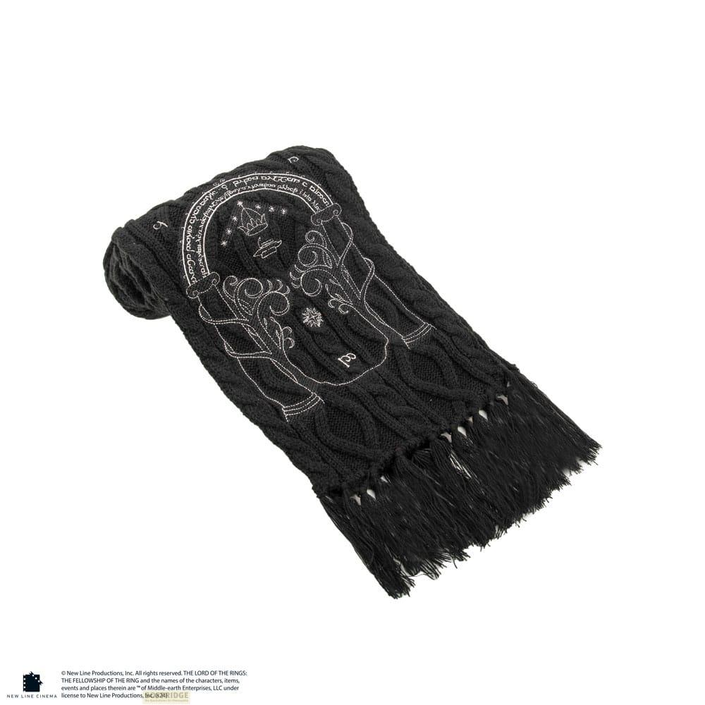 Une écharpe noire avec des motifs argentés, dont une couronne et une inscription.