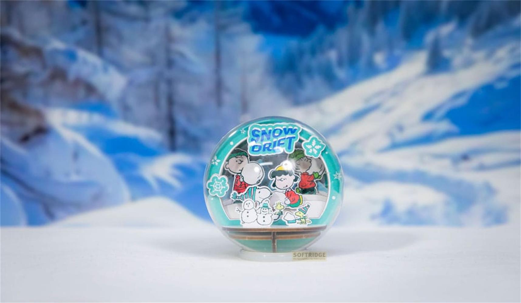 Schneekugel mit Peanuts-Figuren beim Schneemannbauen vor verschneiter Landschaft.