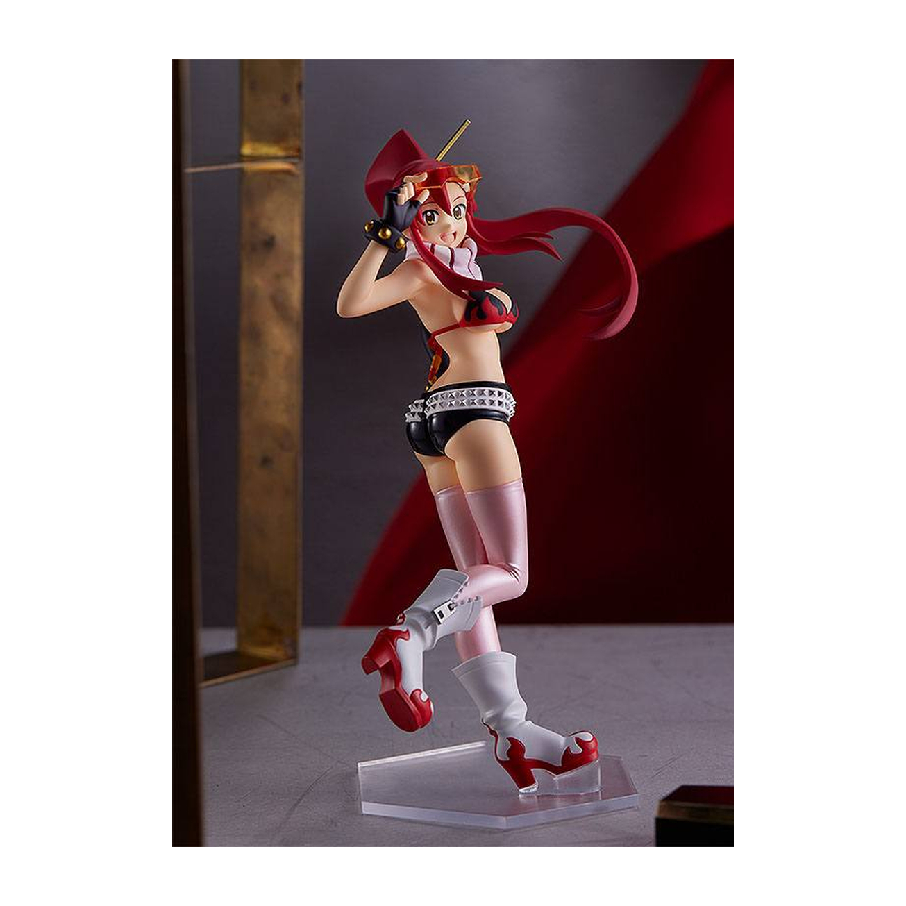 Figura de anime con pelo rojo y bikini al aire libre, sobre peana.