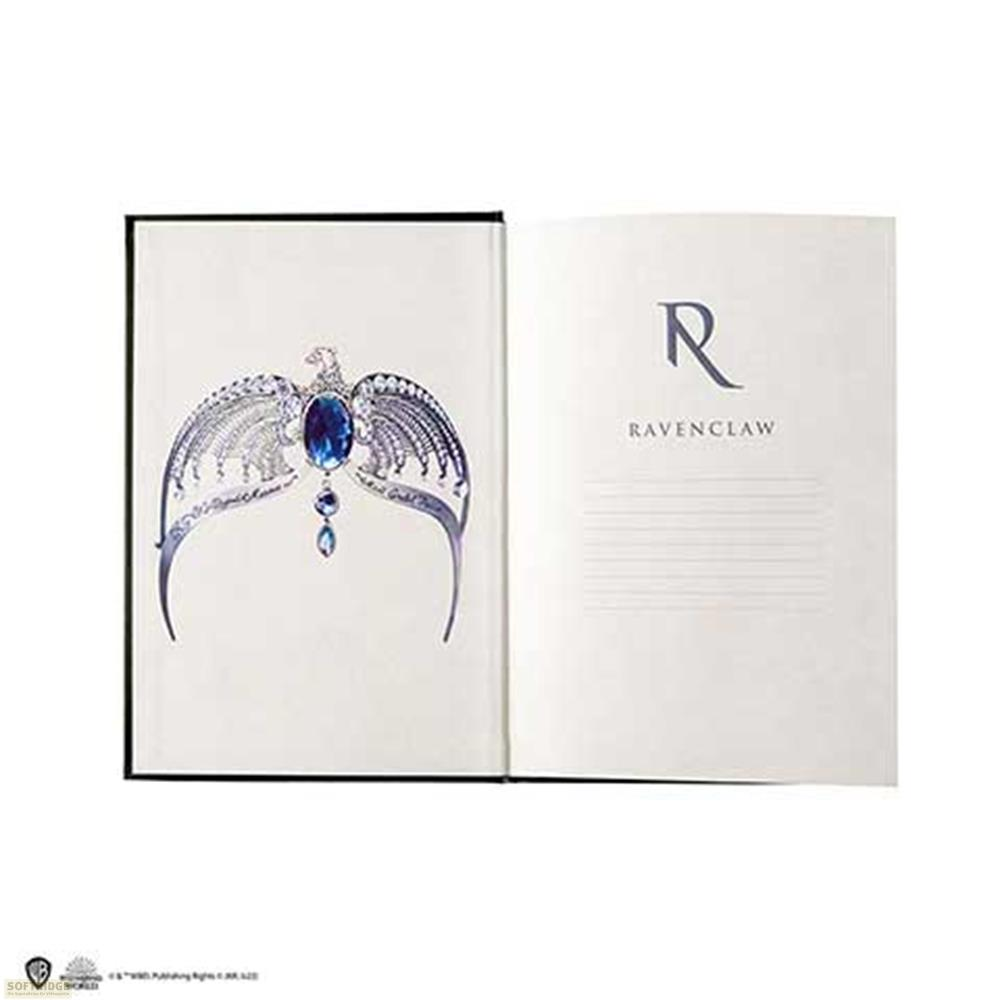 Ein offenes Buch zeigt ein Diadem mit einem blauen Stein und Federn.