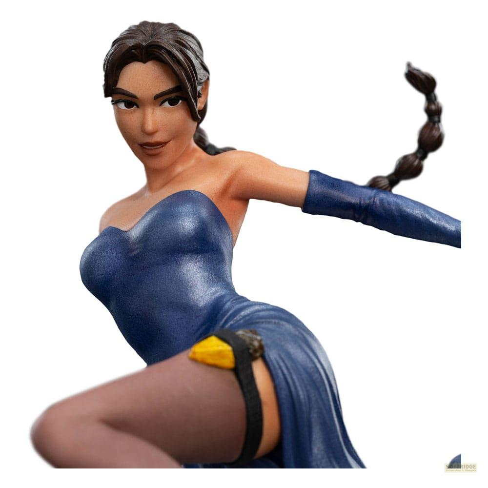 Eine Figur von Lara Croft in einem blauen Kleid mit langen Handschuhen und einem Zopf.