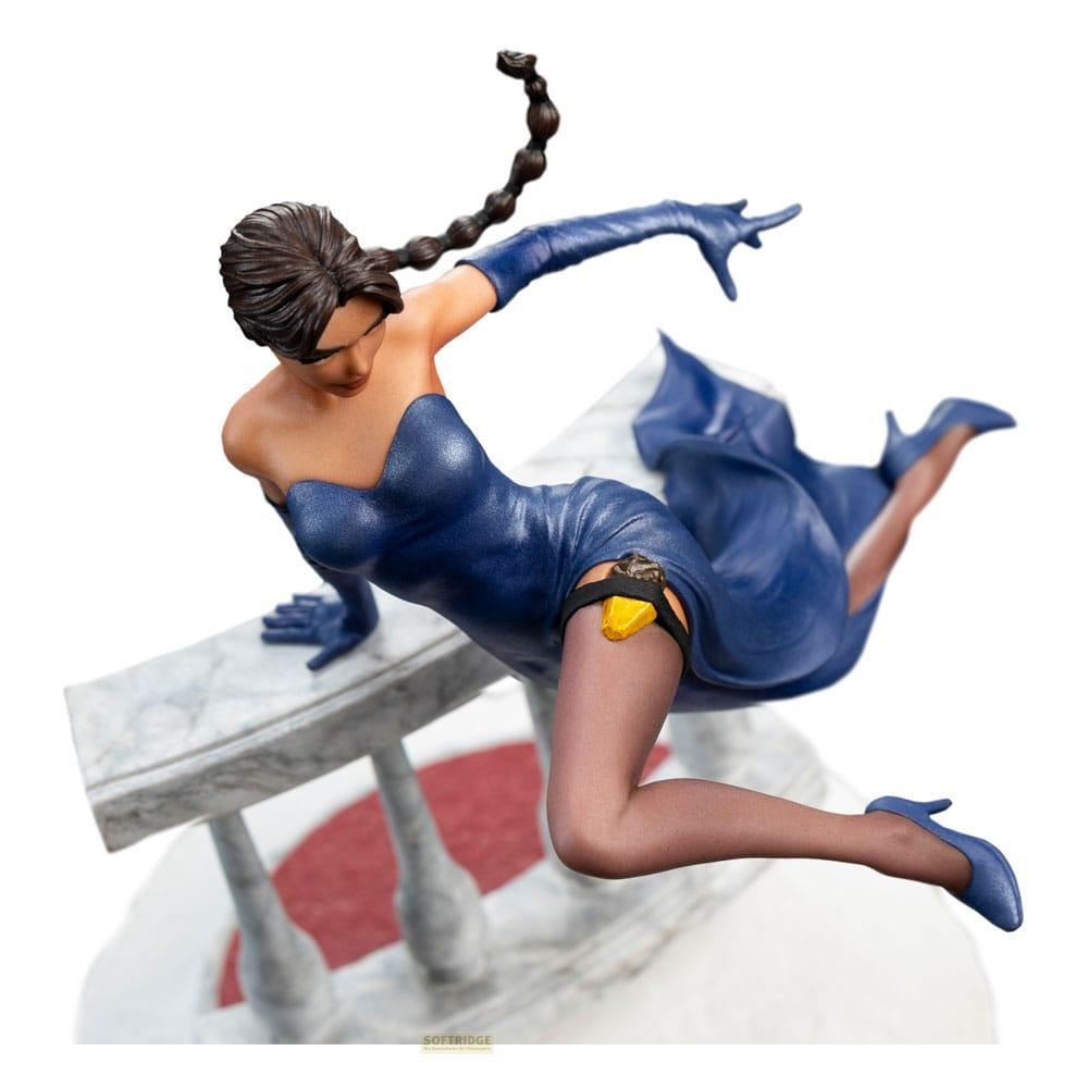 Eine Frau in einem blauen Kleid mit Waffenhalterung auf einer Balustrade.