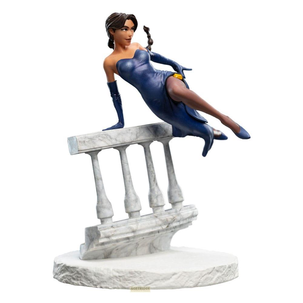 Eine Frau in einem blauen Kleid und Handschuhen lehnt über eine Balustrade.