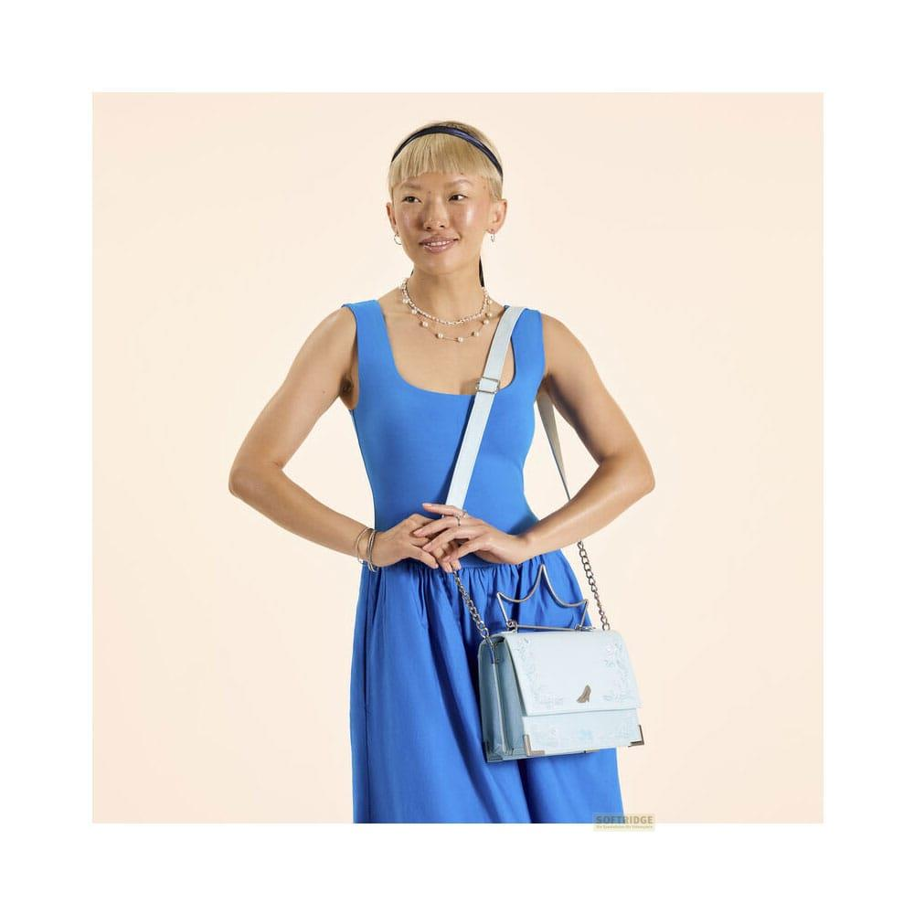 Una mujer con vestido azul y bolso azul claro.