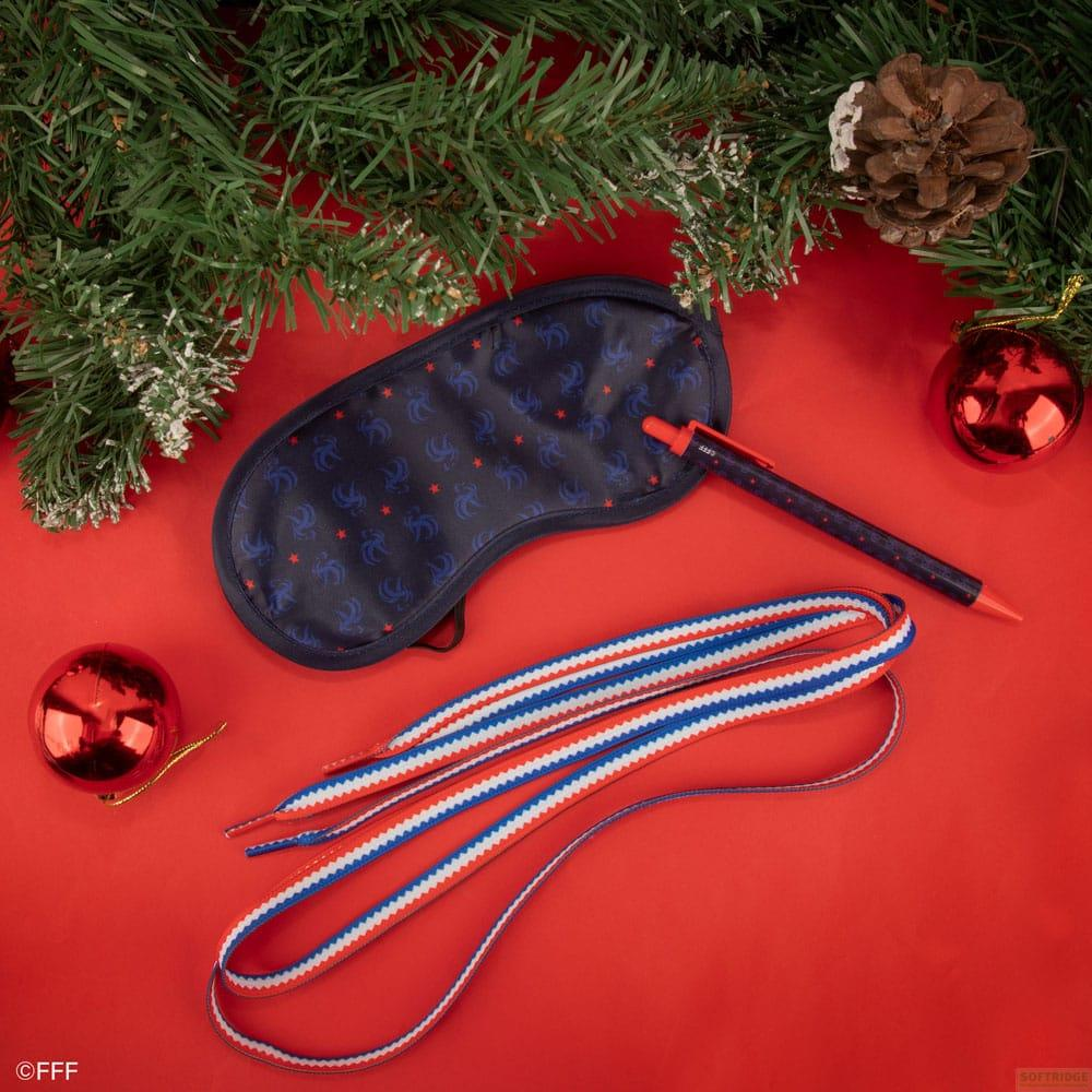 Blaues Schlafmasken-Set mit roten Sternen, Schnürsenkeln und Stift auf rotem Hintergrund.