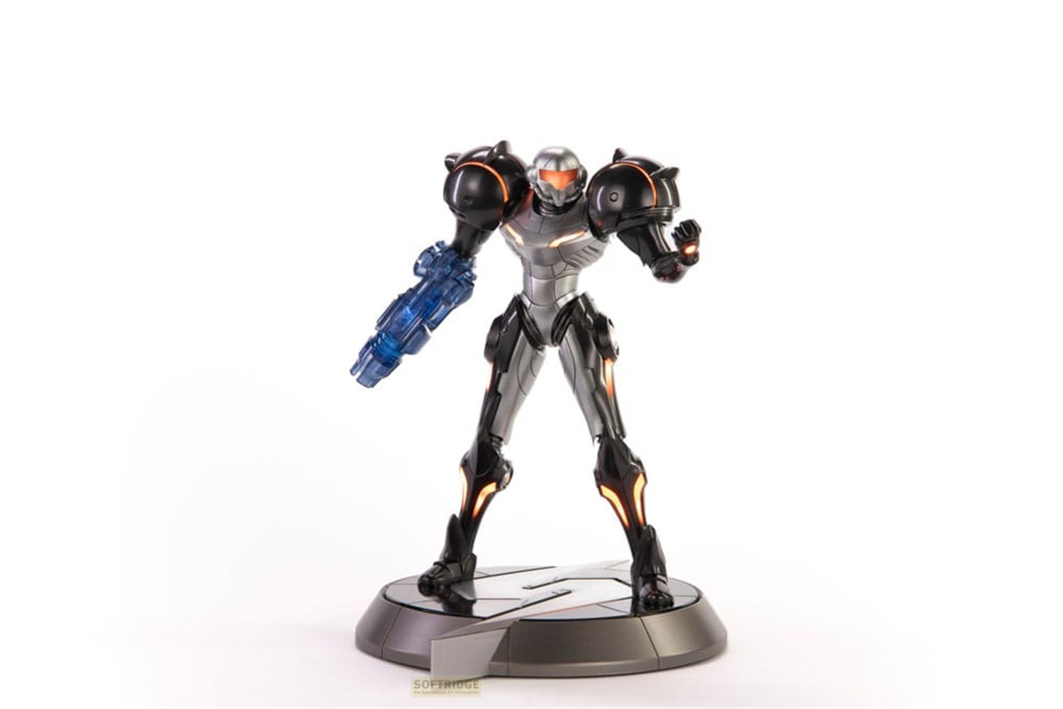 Eine Figur in einem silbernen und schwarzen Anzug mit leuchtenden orangen Akzenten und einer blauen Waffe.