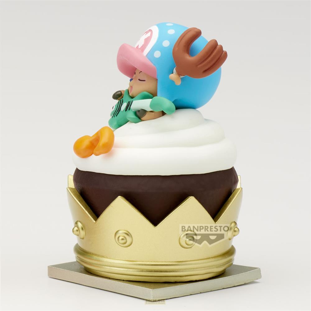 Una figura se sienta en un cupcake con corona dorada, glaseado blanco y pastel marrón.