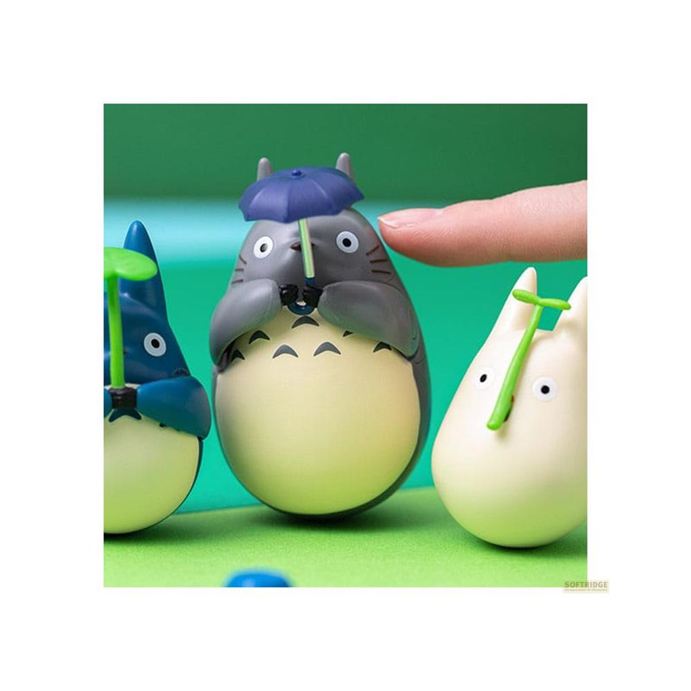 Trois figurines Totoro tenant des parapluies sur fond vert.