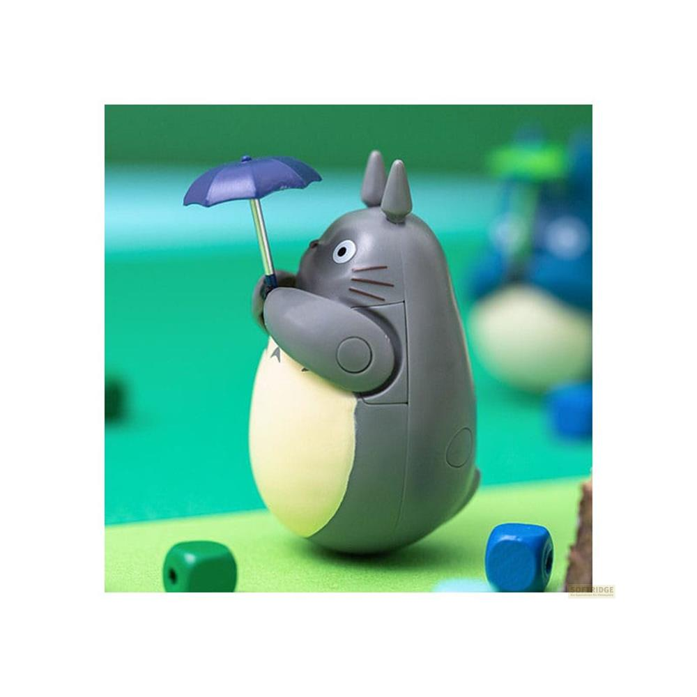 Figurine grise de Totoro tenant un parapluie bleu sur fond vert.
