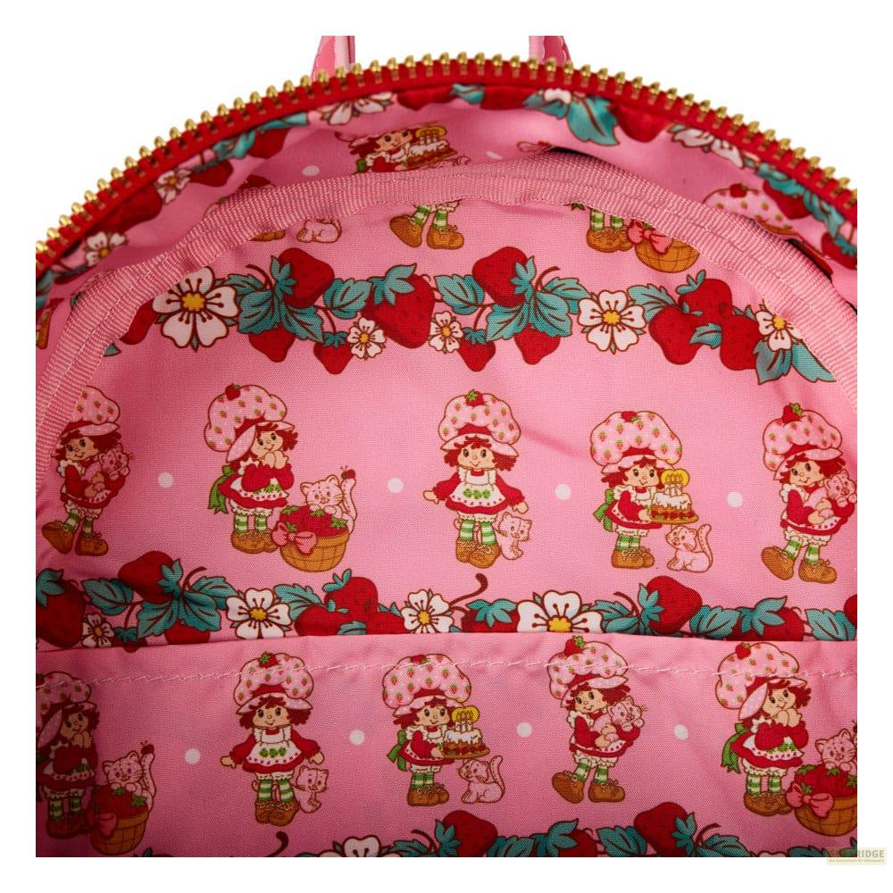 Forro rosa dentro de un bolso con personajes de Frutillita, motivos de fresas y cremalleras doradas.