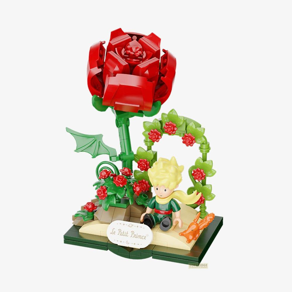 El Principito se sienta junto a una rosa roja y un zorro.
