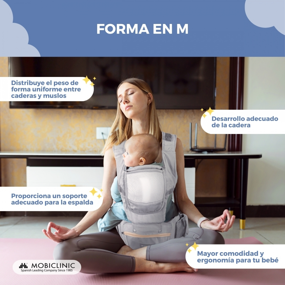 Mujer meditando con bebé en portabebés en esterilla, forma M.