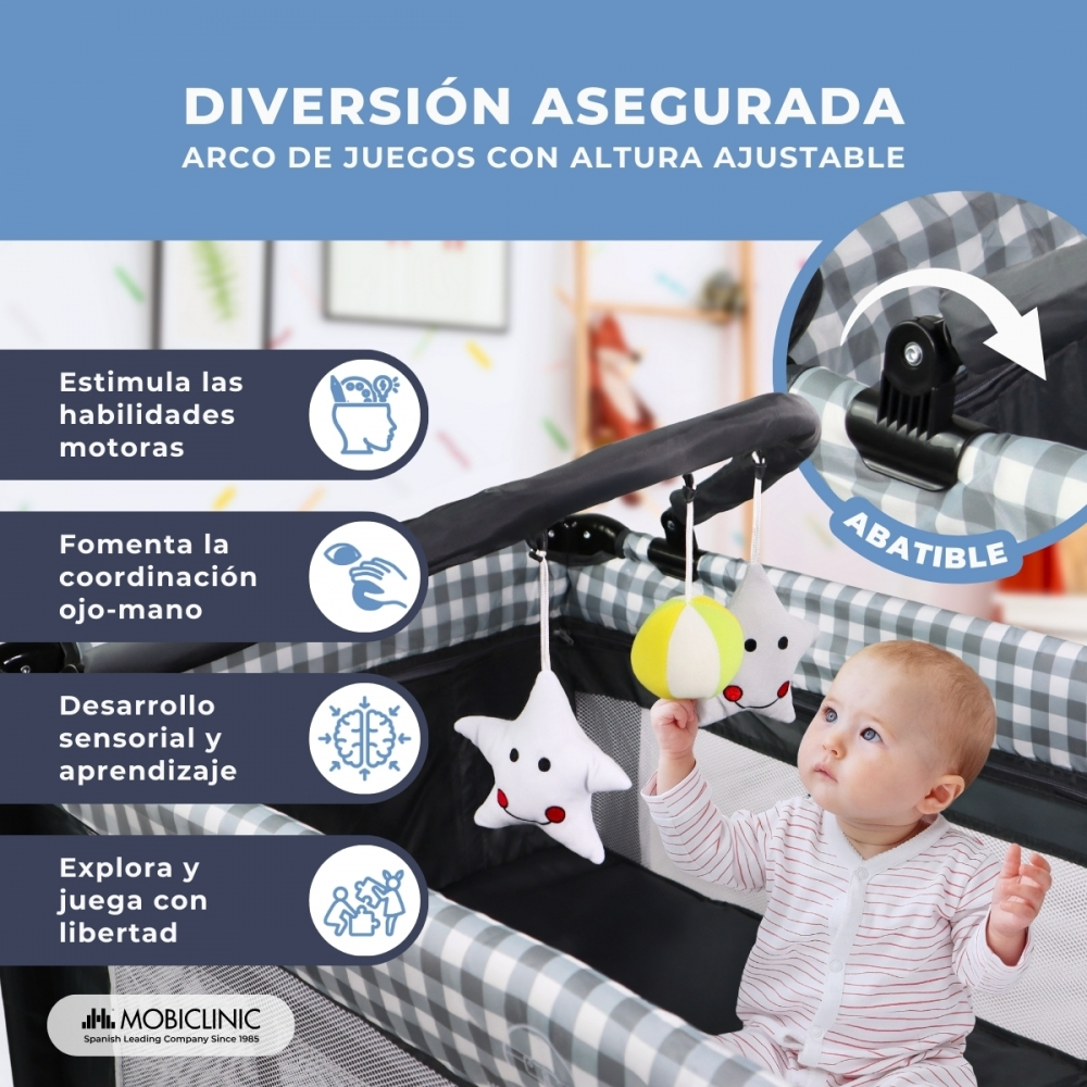 Bebé en corralito con arco de juegos ajustable y juguetes colgantes. Texto sobre motricidad.