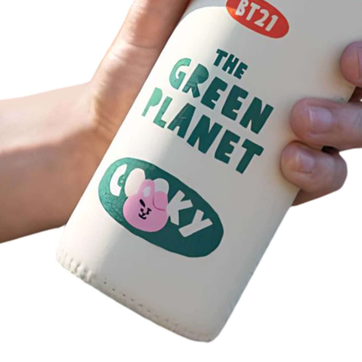 Una mano tiene una tazza bianca con testo verde "THE GREEN PLANET" e Cooky.