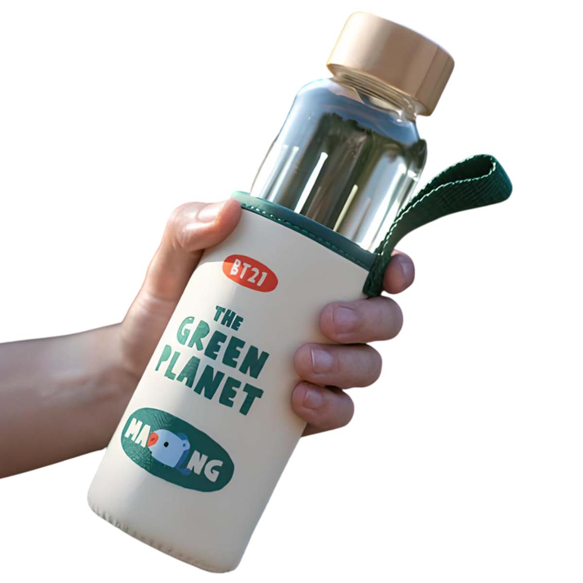 Una mano tiene una bottiglia di vetro con manica beige. Logo BT21 in alto.