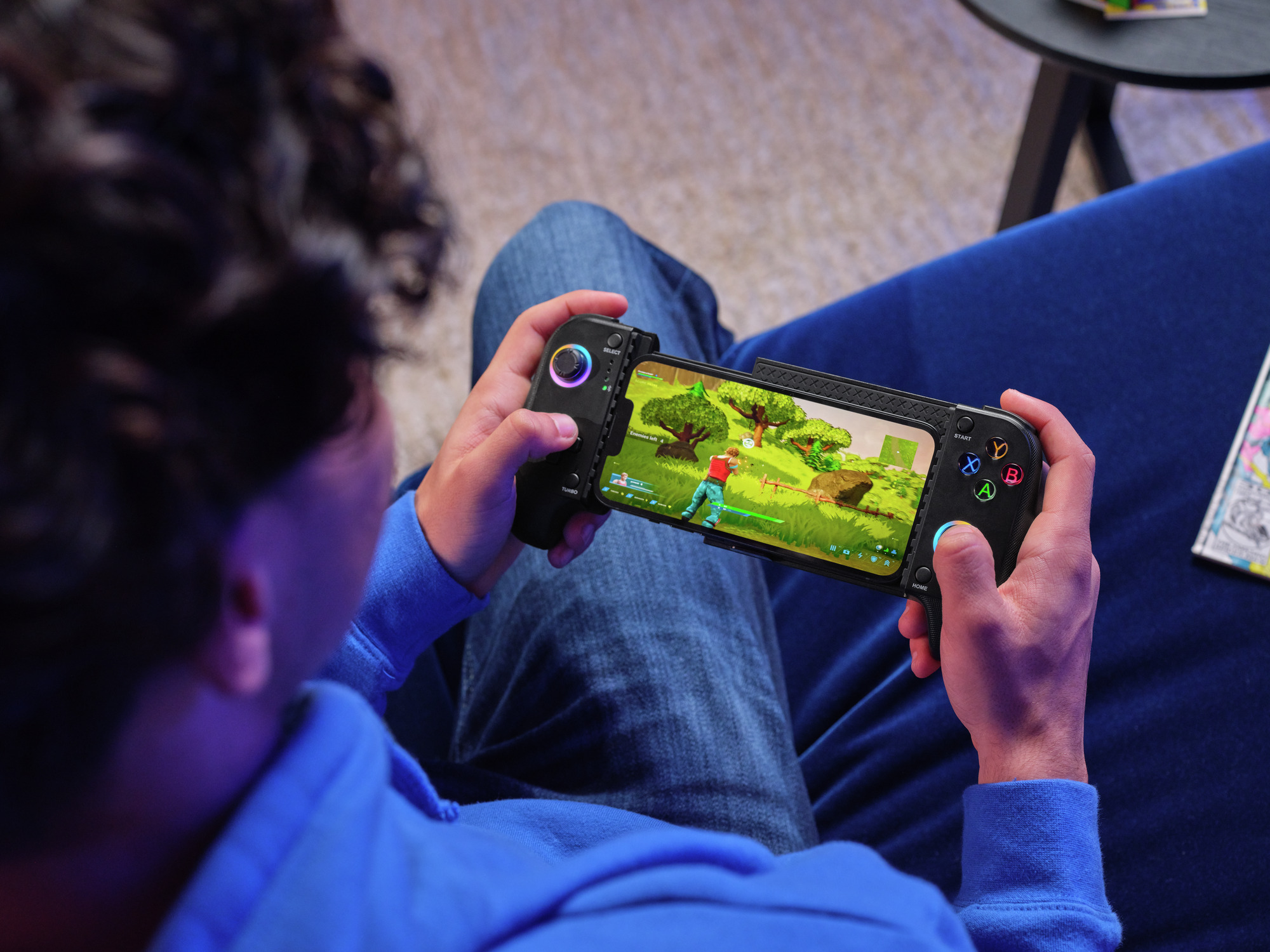 Osoba gra w grę wideo na telefonie komórkowym z dołączonym kontrolerem.