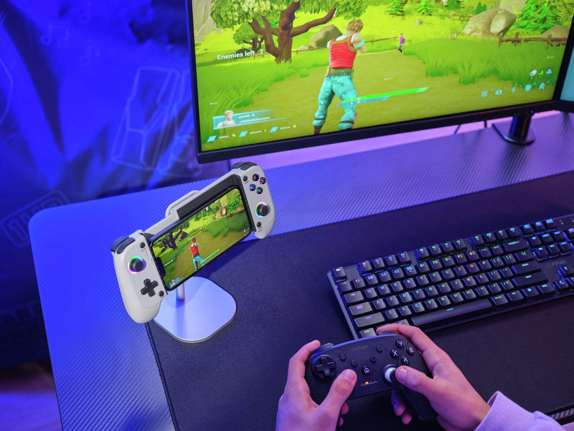 Gaming-Setup mit Monitor, Tastatur und zwei Controllern, spielt ein Spiel.