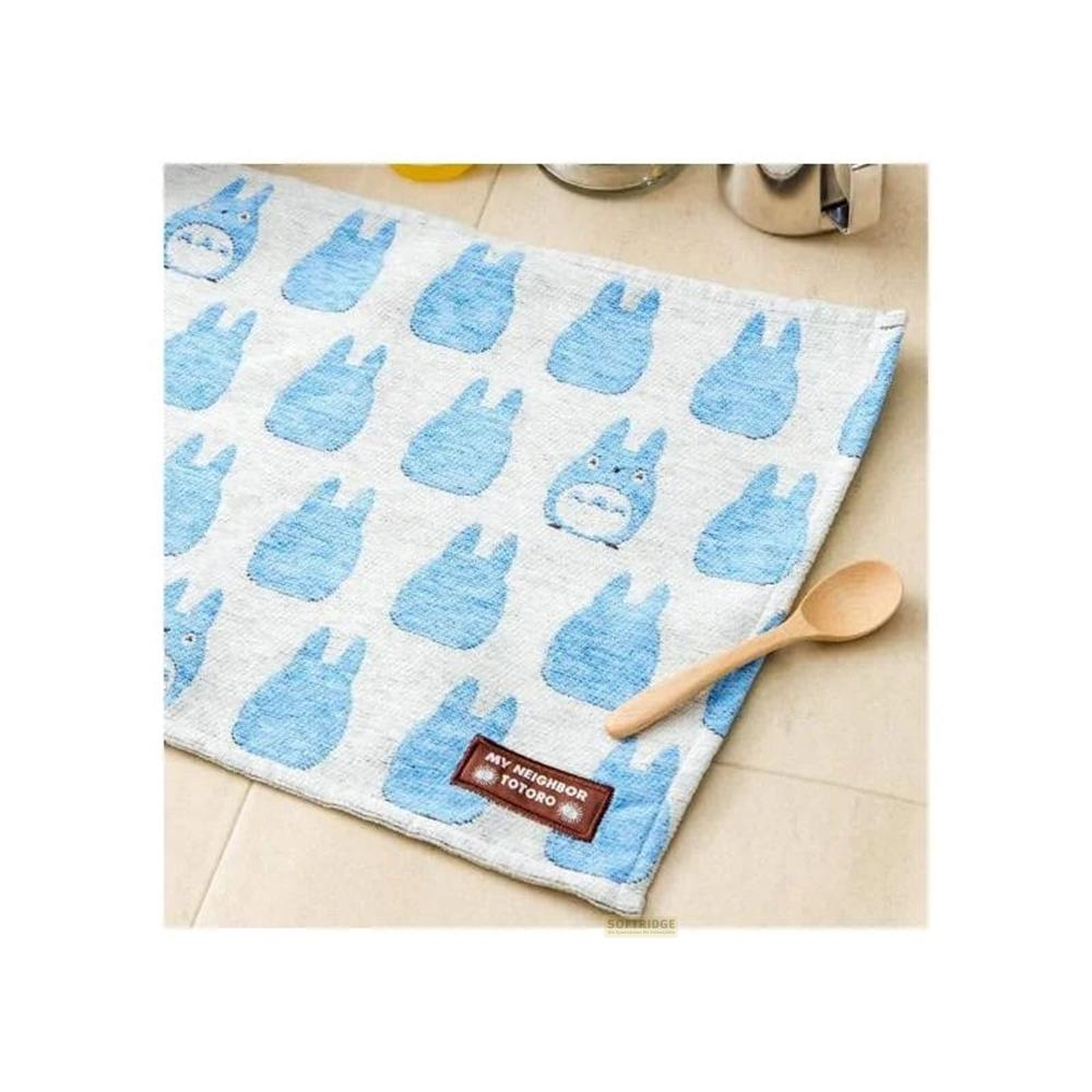Une serviette avec un motif bleu de Totoro et une cuillère en bois.