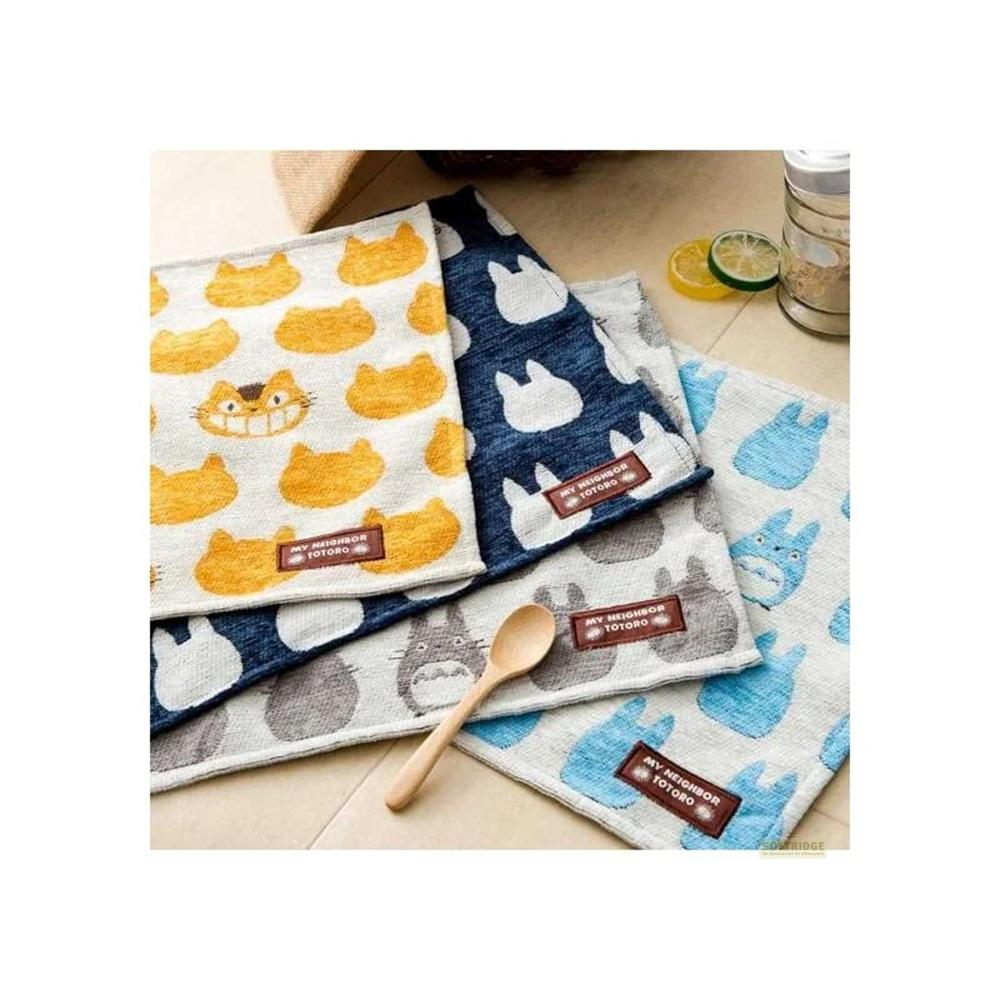 Plusieurs torchons sur le thème de Totoro, jaunes, bleus et gris, avec une cuillère en bois.