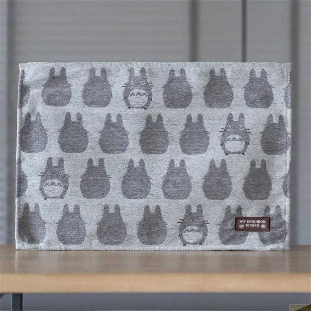Tissu gris à motif Totoro, sur une table en bois.
