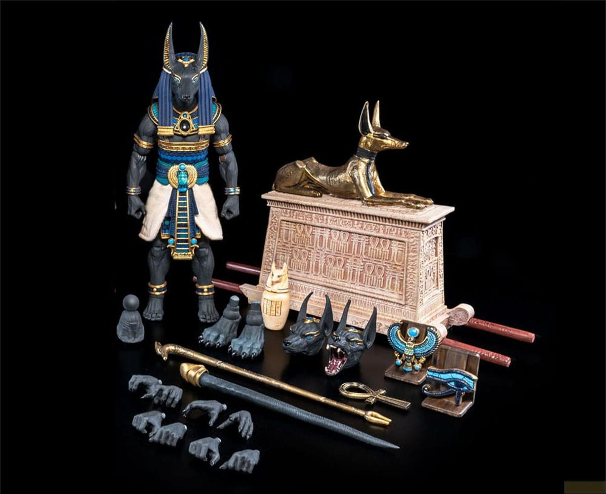 Divinità egizia con accessori: figura di Anubi, statue, ankh e Occhio di Horus.